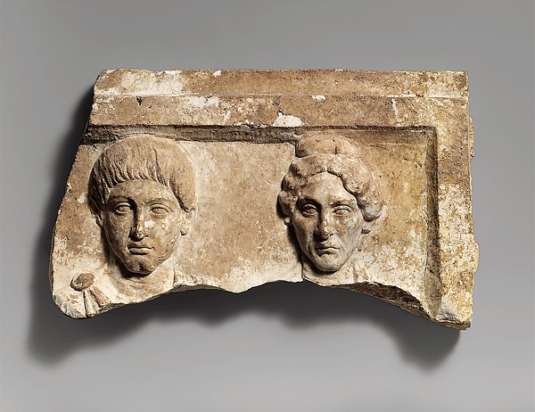 Top of a marble funerary relief with portrait busts of a young man and an elderly woman